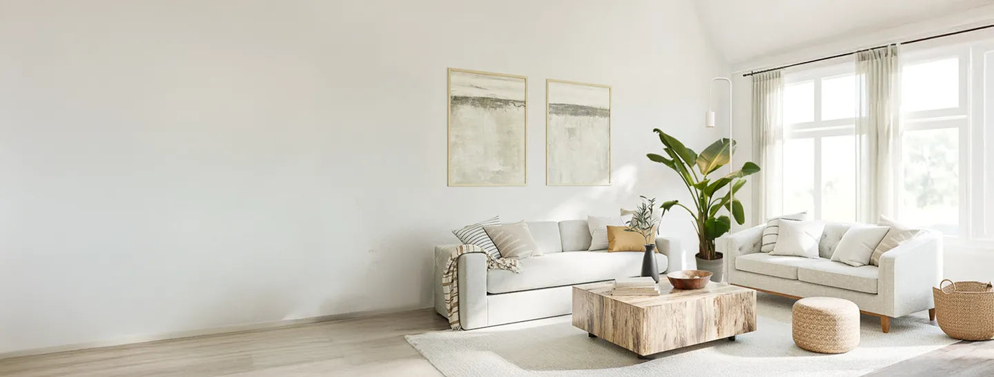 Modern living room with white sofas, a coffee table, and decorative items.