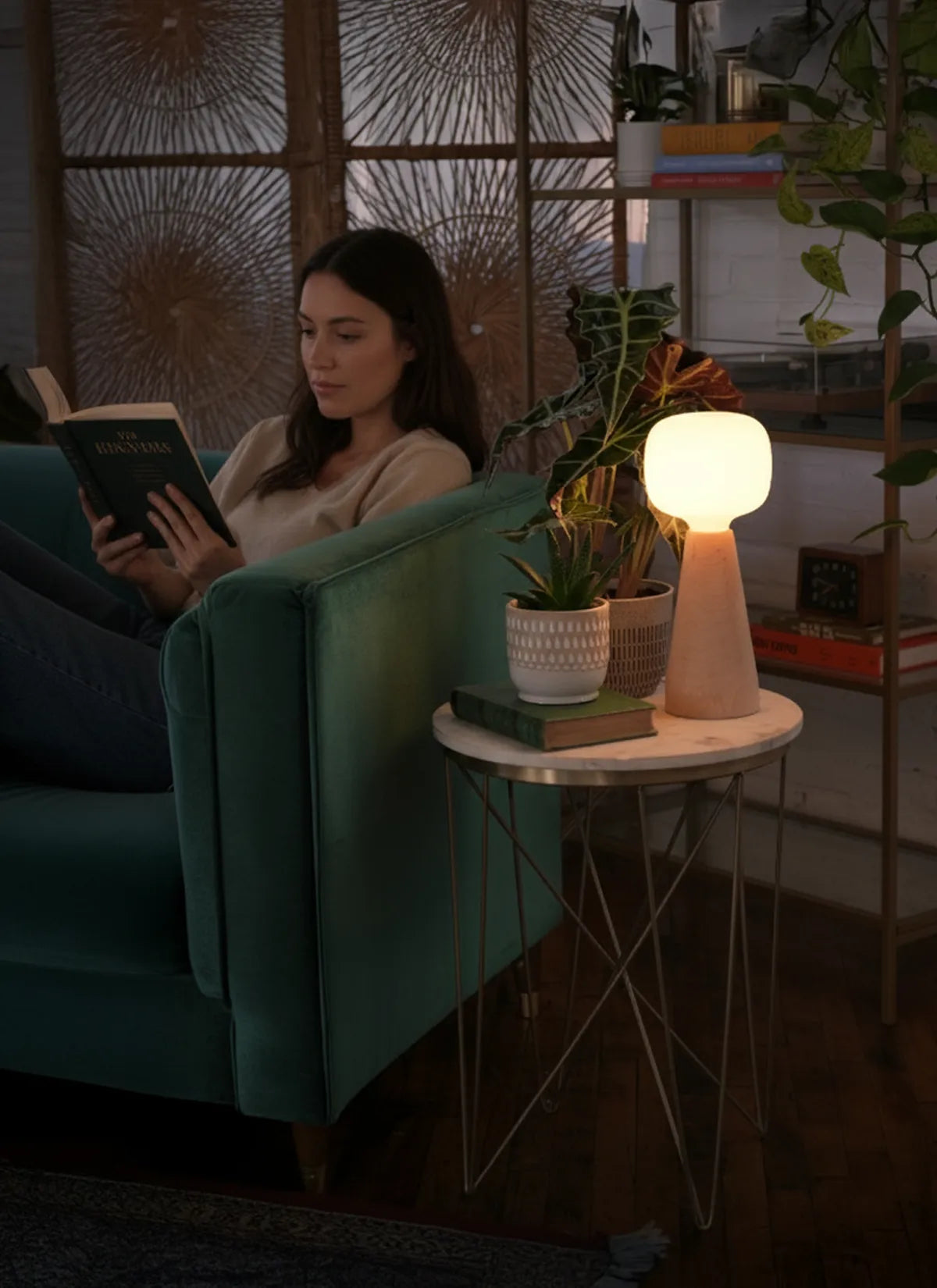 Woman reading a book in a cozy living room with a Soltech Aura and plants.