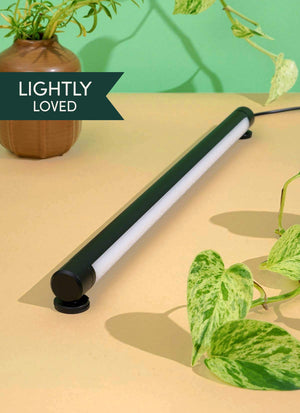 A Black Soltech Grove laid on a tabletop with a plant in the background. The text 'LIGHTLY LOVED' is visible on the image.