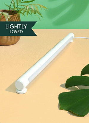A White Soltech Grove laid on a tabletop with a plant in the background. The text 'LIGHTLY LOVED' is visible on the image.