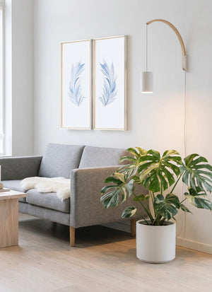 Modern living room with gray sofa, plant, and wall art