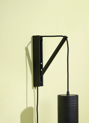 Black Soltech Pinocchio wall mount and black Soltech Aspect against a yellow background.